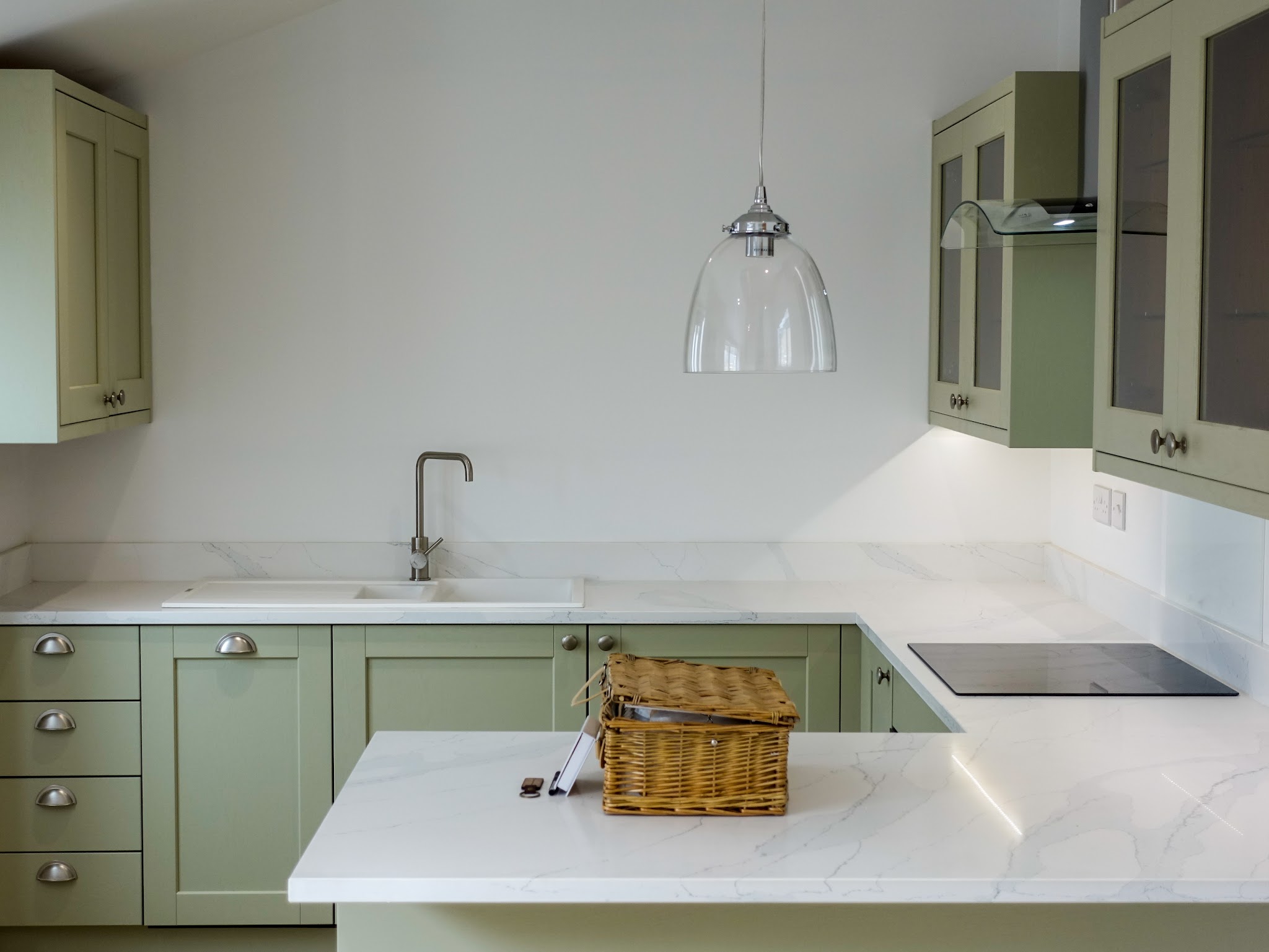 Kitchen with sage green shaker units and white walls